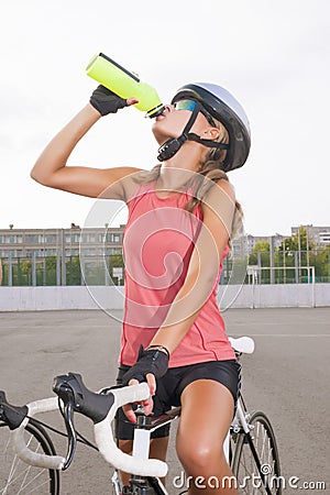 Cyclist woman takes a water break