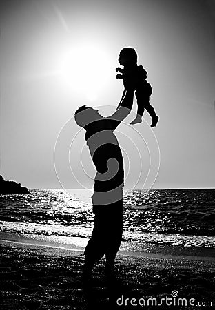 Dad and child on the beach at at sunset