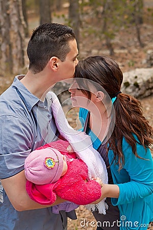 Dad Kissing Mom’s Forehead and Holding Baby