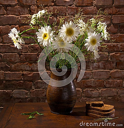 Daisies in vase and bakery pieces of bread