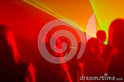 Dancing people in red and yellow laser light