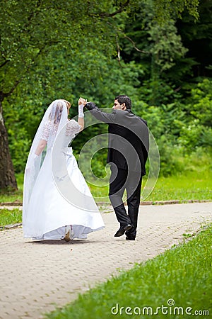 Dancing wedding couple at a park