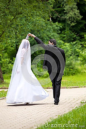 Dancing wedding couple at a park