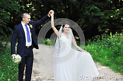 Dancing wedding couple in a park