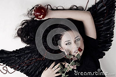 Dark angel girl with a red apple and rose