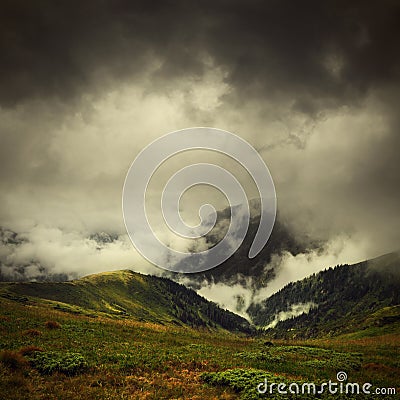 Dark clouds and fog over mountain valley