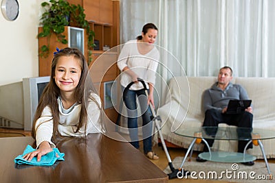 daughter-helping-mother-to-clean-cute-father-resting-couch-64549064.jpg