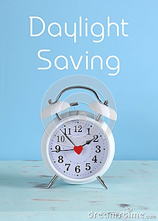 Daylight savings time white clock on a vintage aqua blue wood table