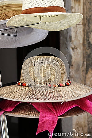 Delicate straw hats on a stand