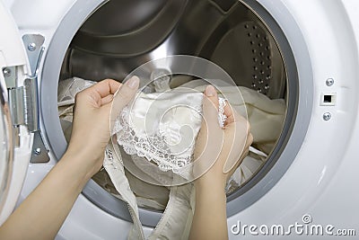 Delicate wash, woman taking delicate laundry (underwear) from wa