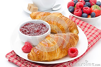 Delicious breakfast - fresh croissant with raspberry jam, coffee