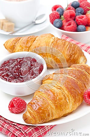 Delicious breakfast - fresh croissant with raspberry jam, coffee