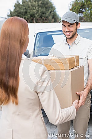 Delivery driver passing parcels to happy customer