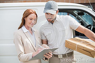 Delivery driver showing where to sign to customer