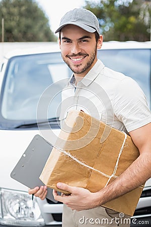 Delivery driver smiling at camera by his van