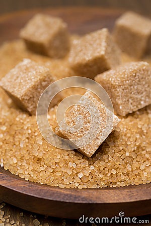 Demerara sugar and brown sugar cubes in a bowl, selective focus