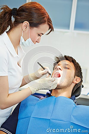 Dental assistant examining patient