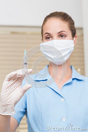 Dental assistant holding injection looking at it