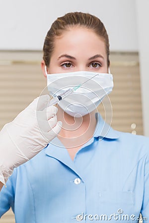 Dental assistant holding injection looking at it