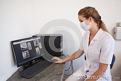 Dental assistant looking at x-rays on computer