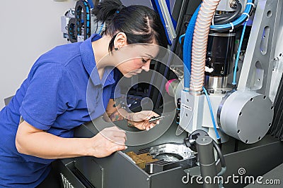 Technician in a dental lab working at a drilling or milling machine