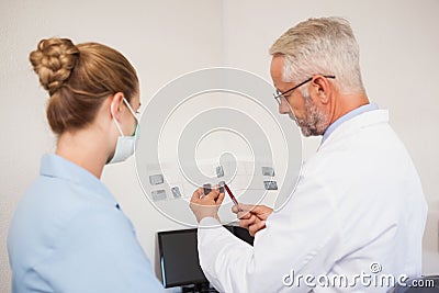 Dentist and assistant studying x-rays