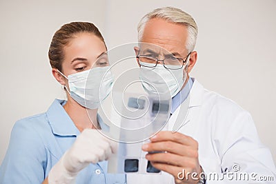 Dentist and assistant studying x-rays