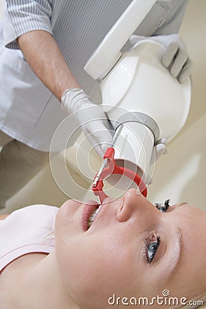 Dentist in exam room with woman in chair