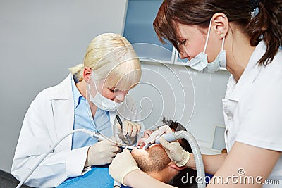 Dentist performing dental surgery on patient