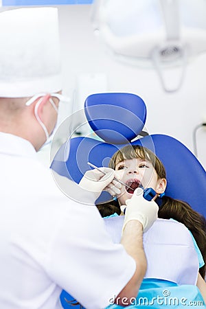 Dentist using dental filling gun on kid