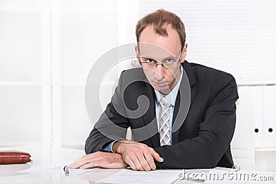 Depressed manager with crisis sitting at desk.