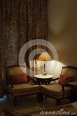 Desk lamp and two chairs in the room of hotel