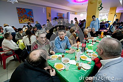 Different people talking at the tables at the Christmas charity dinner for the homeless