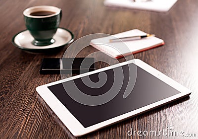 Digital tablet computer with note paper and cup of coffee on old wooden desk
