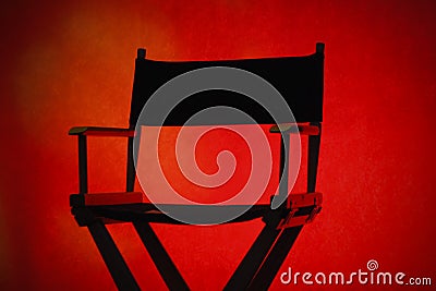 Silhouette of a traditional wood and canvas Director's Chair on a red 