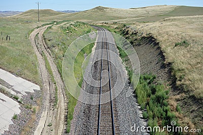 A dirt road running beside train tracks in wyoming.