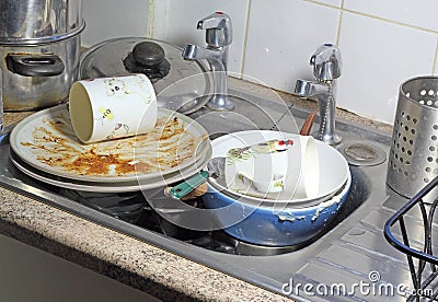 Dirty dishes in a sink for washing up.