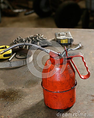 Dirty red oil can on work bench