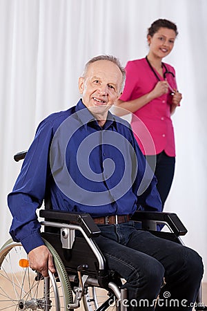 Disabled man and nurse in the background