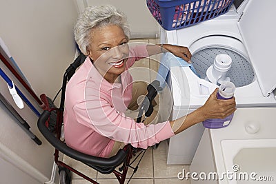 Disabled Senior Woman Doing Laundry At Home