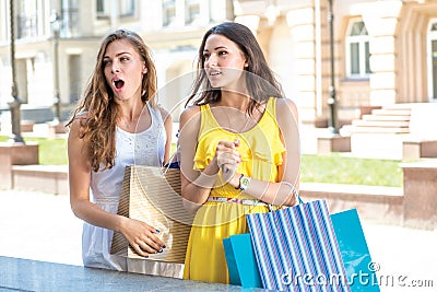 Discounts at the outlet store. Girls holding shopping bags and s