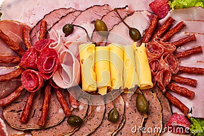 Dish with sliced ham, cheese, salami rolls and let