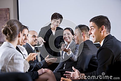 Diverse businesspeople conversing, woman at front