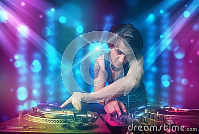 Dj mixing music in a club with blue and purple lights