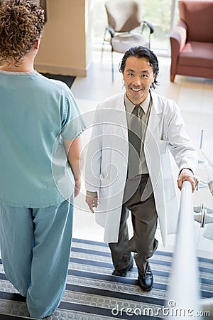 Doctor Climbing While Nurse Walking Down Hospital