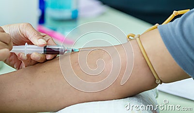 Doctor drawing blood sample from arm