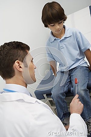 Doctor Examining Boy With Reflex Hammer