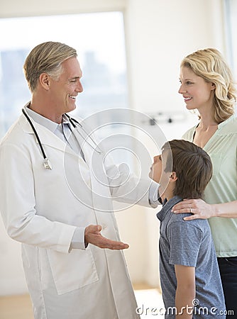 Doctor Explaining Woman About Son s Health In Clinic