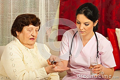 Doctor gives pills to senior woman