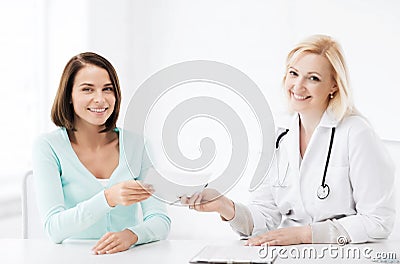 Doctor giving prescription to patient in hospital